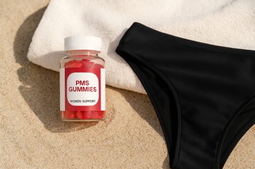 Nyári Aqua Csomag: PMS gumicukor és AquaFlow fekete menstruációs bikini alsó homokos strandháttéren, napfényes környezetben.